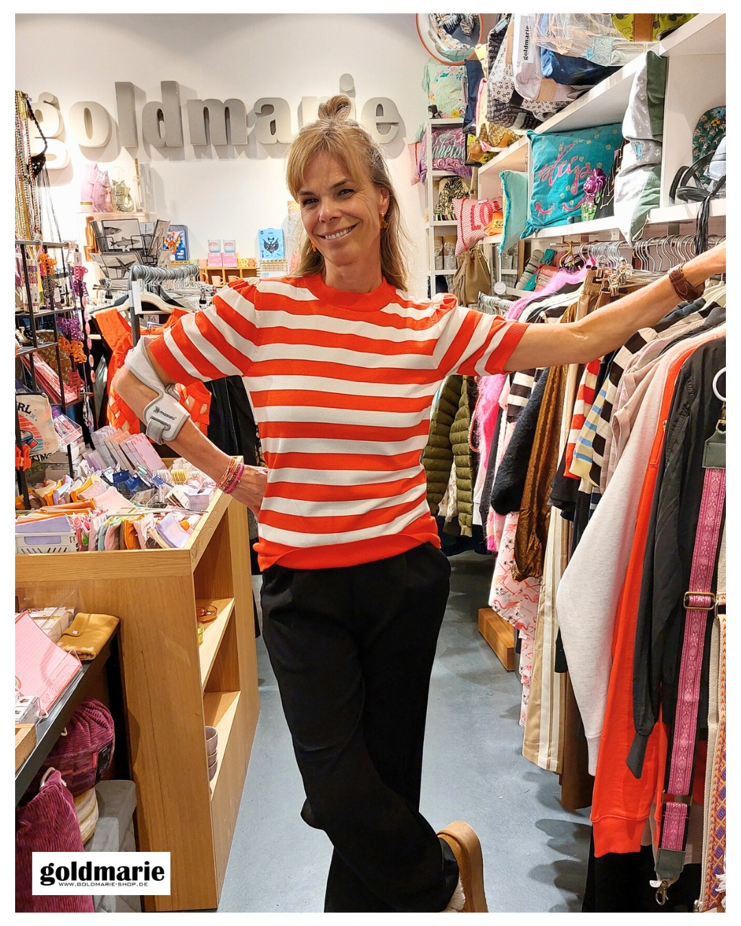 goldmarie mit gestreiften Shirt steht im Laden